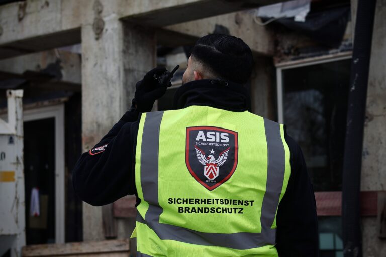 ASIS Sicherheitsdienstmitarbeiter kommuniziert per Funkgerät während der Baustellenbewachung