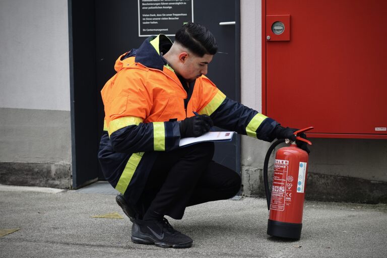 ASIS Sicherheitsdienst-Mitarbeiter führt eine Brandschutzkontrolle mit einem Feuerlöscher durch