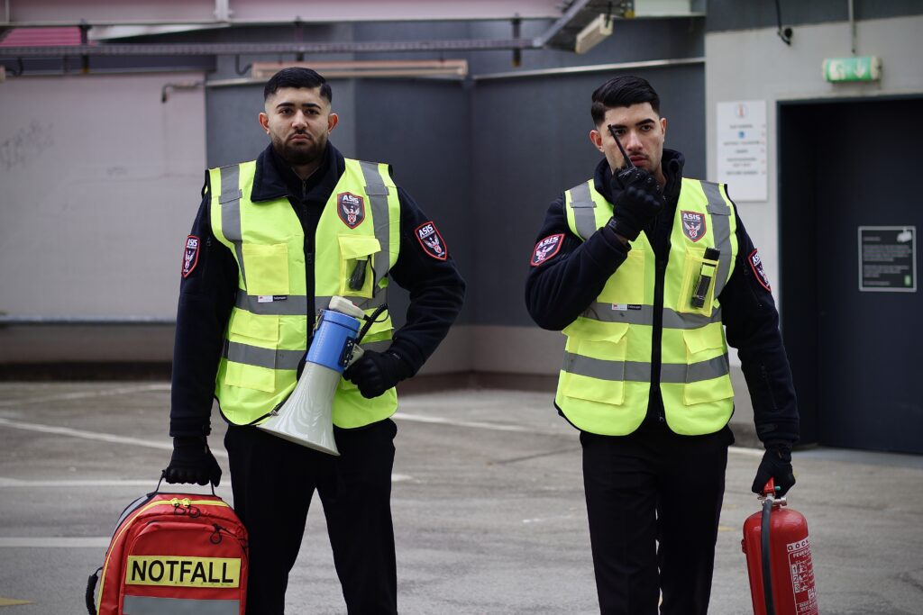 Zwei ASIS Sicherheitsmitarbeiter ausgestattet mit Notfalltasche und Feuerlöscher für höchste Sicherheitsansprüche