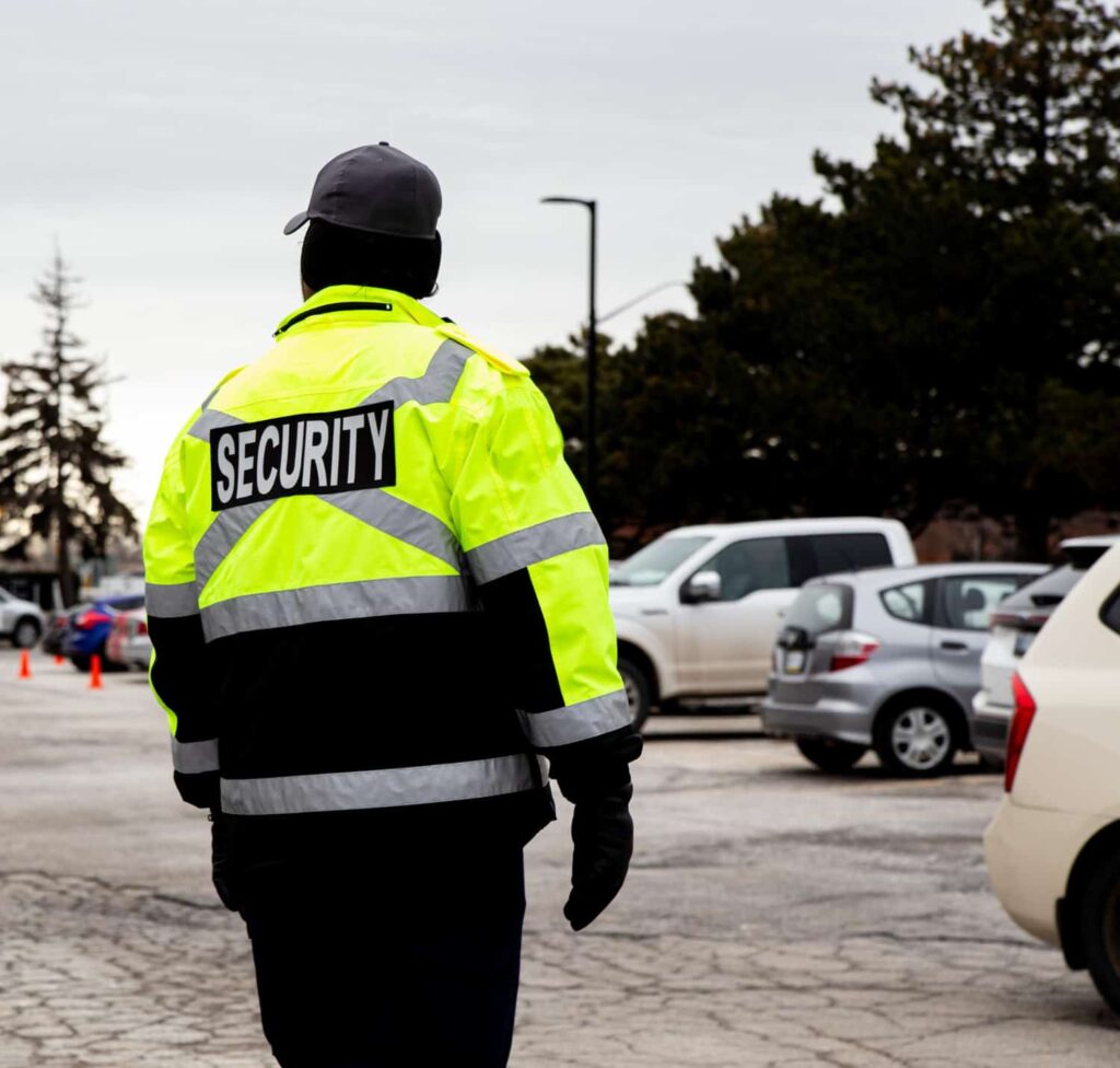 Sicherheitsdienst Hoyerswerda bei Streifengang auf einem Parkplatz mit Warnjacke.